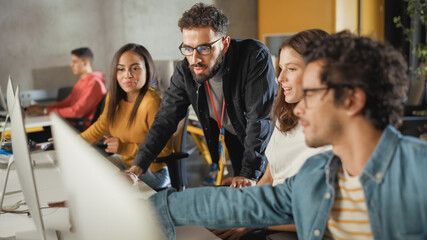 Fototapete - Lecturer Helps Scholar with Project, Advising on Their Work. Teacher Giving Lesson to Diverse Multiethnic Group of Female and Male Students in College Room, Teaching New Academic Skills on a Computer.
