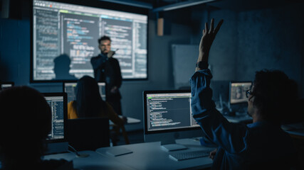 Fototapete - Teacher Giving Computer Science Lecture to Diverse Multiethnic Group of Female and Male Classmates in Dark College Room. Student Raises Hand and Answers Lecturer a Question About Software Engineering.