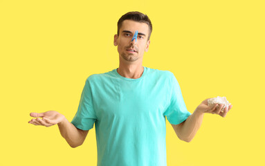 Canvas Print - Ill young man with clothespin on his nose against color background