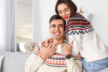 Poster - Happy young couple wearing warm sweaters at home