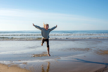 Wall Mural - pretty girl full of vitality running and jumping on the sunny beach