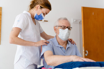 kinesiologist, female occupational therapist massaging an older man for rehabilitation of shoulder tendinitis