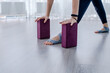 Close-up a woman leans her palms on purple yoga blocks