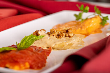 Wall Mural - A Trio of Large Ravioli on a plate with three types of sauce.