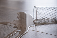 A Glass Of Water Spilled Onto The Floor. Waterproof Laminate, Concept