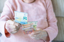 Wrinkled Hands Holding Euro Banknotes