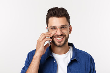 Wall Mural - Smiling guy talking on a mobile phone isolated on white background.