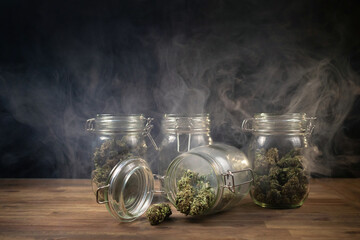 Wall Mural - CBD hemp weed buds stored in a glass jar shrouded with a smoke cloud. Medical cannabis.