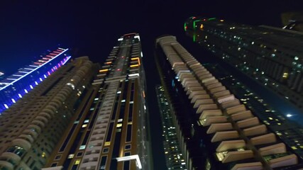 Wall Mural - DUBAI, UAE - DECEMBER 5, 2016: Walking along Dubai Marina at night with skyscrapers lights