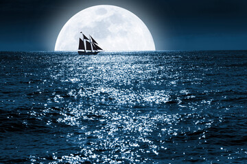 Wall Mural - very large full blue moon rises over this ocean scene as a sailboat quietly saiils in front of it at