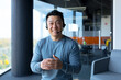 © Liubomir - Happy telemarketing worker looking at camera and smiling, asian with headset, video call portrait