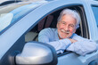 © Daniel - Happy owner looking at the camera with happy face. Handsome bearded mature man sitting relaxed in his newly bought car looking out the window smiling joyfully. One old senior driving and having fun..