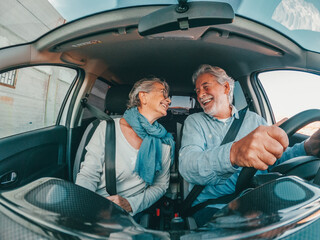 Wall Mural - Couple of two happy senior having fun and enjoying vacations trip together driving and discovering new places with a car. 
