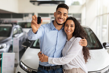 Wall Mural - Happy middle-eastern family buying new car in luxury showroom