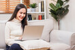 © khwanchai - Asian beautiful woman working on laptop on sofa at home