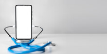 Mockup phone with stethoscope on light grey background. Mockup image medical stethoscope and mobile cell phone with blank screen. online medicine, doctor online consultation concept. copy space