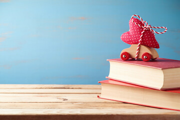 Poster - Valentines day concept with toy car, heart shape and books on wooden table