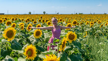 In Sunflowers In A Red Dress In Sunglasses, Beautiful Blonde In The Heat Of Summer Bright Light