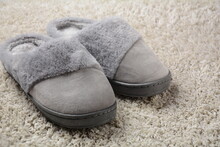 A Female Warm Slippers On Grey Mat. Pair Of Comfortable Slippers