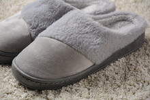 A Female Warm Slippers On Grey Mat. Pair Of Comfortable Slippers