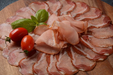 Wall Mural - Italian cured pork shoulder. Antipasto Platter coppa stagionata and cherry tomatoes.  Traditional sliced sausage with spices