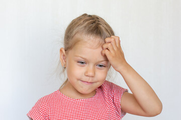 Portrait of smiling and thinking caucasian child kid little girl of 5 years on grey background looking down