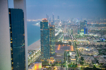 Wall Mural - Abu Dhabi aerial skyline at night. City tall buildings along Corniche Road.