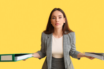 Wall Mural - Beautiful young woman with folders on color background