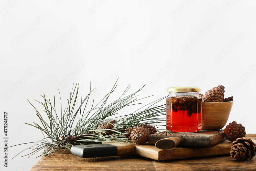 Jar of tasty pine cone jam on wooden table