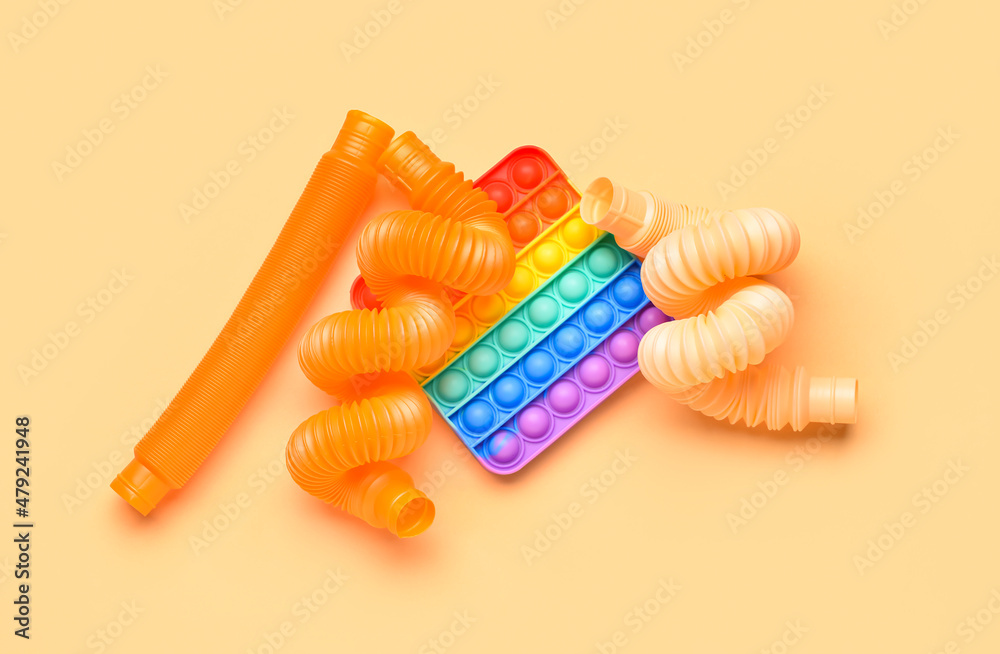 Colorful Pop Tubes and Pop it fidget toy on beige background