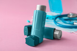 Fototapeta Sypialnia - Asthma inhalers on pink background, closeup