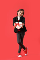 Poster - Funny little girl with gift on color background. Valentine's Day celebration