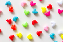Valentine's Day Background. Pink, Red, Green, Blue Hearts On A Pastel White Background. The Concept Of Valentine's Day. Beads In The Form Of Hearts. Flat Layout, Top View, Copy Space