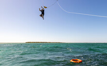 Man Falls From Spinnaker Ride High In The Air Into The Deep Blue Ocean Water Near Cozumel, Mexico For An Adventure.