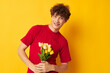 © Tatiana - Young curly-haired man in a red T-shirt with a bouquet of flowers Lifestyle unaltered