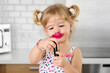 © Lisa Tichané - Smiling toddler girl with messy face holding lipstick