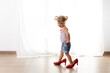 © Lisa Tichané - Toddler girl with funny attitude walking with mother's high heels