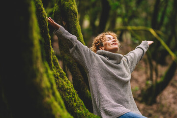 overjoyed happy woman enjoying the green beautiful nature woods forest around her - concept of femal