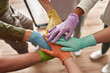 © Svitlana - Team in medical gloves stack hands on each other