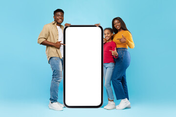 Black family pointing at big huge empty smartphone screen, mockup