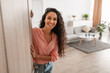 © Prostock-studio - Cheerful young curly lady inviting people to enter home