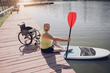 Wall Mural - Person with a physical disability who uses wheelchair will be ride on sup board