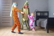Children brothers and sisters in kigurumi pajamas play blind man's buff at home