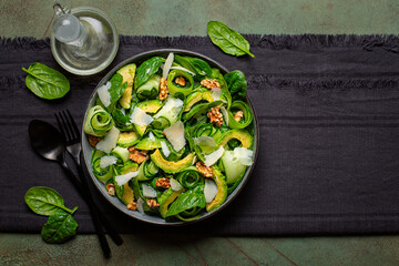 Poster - Spinach, avocado, cucumber, walnut and parmesan cheese salad. Olive oil. Top view. Copy space.