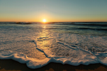 Wall Mural - Foam surf on the Atlantic coast during a beautiful sunset.