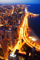 Traffic moves along Lakeshore Drive in Chicago as it moves up the Lake Michigan shore while the lights of the city take effect at night as seen in an aerial view