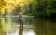 © shandor_gor - A woman stands in the river and fishes with a spinning rod
