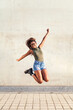 © Raul Mellado - young black woman jumps happy and smiling