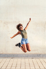 young black woman jumps happy and smiling