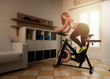 Blond woman spinning at home exercising for their legs and cardio training